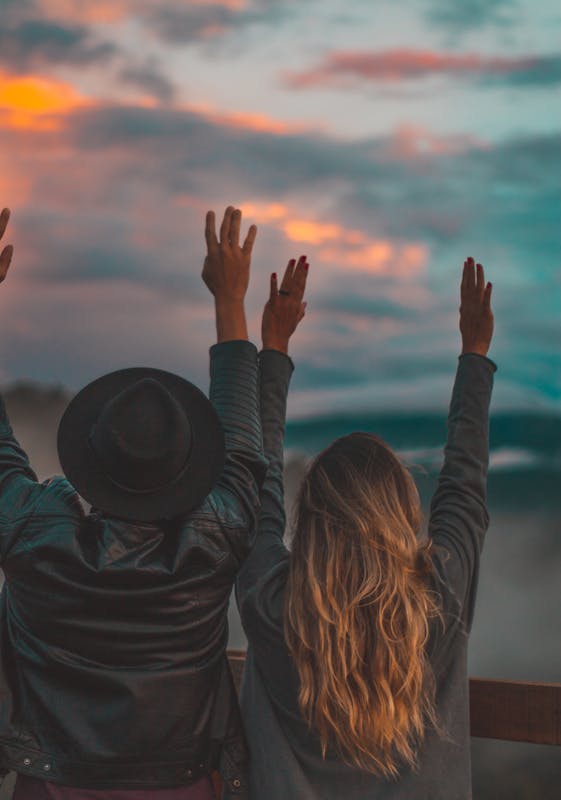 Couple enjoying sunset with arms raised in Monte Verde, Brazil.