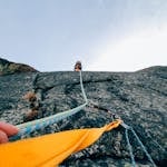 Capture the thrill of rock climbing with this dynamic low-angle shot showcasing determination and teamwork.