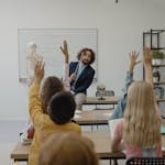 A classroom with a teacher and students actively participating in a lesson about biology.